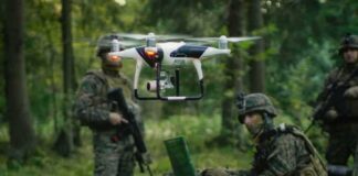 quadcopter drone hovering near soldiers in a forest